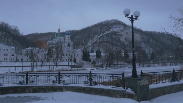 Few People Watching Sviatohirsk Lavra in Evening Winter Landscape From Observation Deck Bare Branch Trees on a Hills Mountainous Terrain Exterior of Church