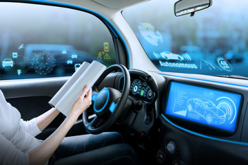 cockpit of autonomous car. a vehicle running self driving mode and a woman driver being relaxed.