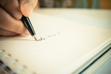 Hand writing word i love you text with pen in notebook
