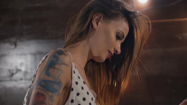 A sexual worker of a barber shop shaves a brutal bearded man in Slow motion. The girl in a short dress sits on a brutal man and shaves him with a dangerous razor.