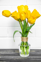 transparent vase with yellow tulips