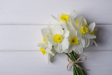 Background with white narcissus  on white wooden  background