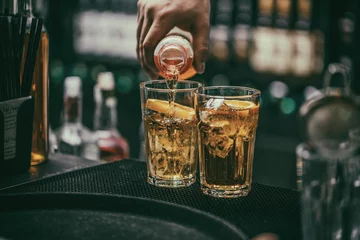 Crédence de cuisine en verre imprimé Cocktail Le barman verse une boisson alcoolisée