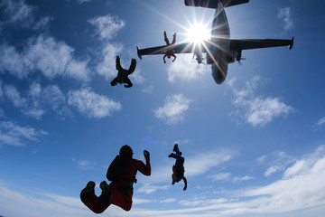 Skydivers are jumping out of a plane