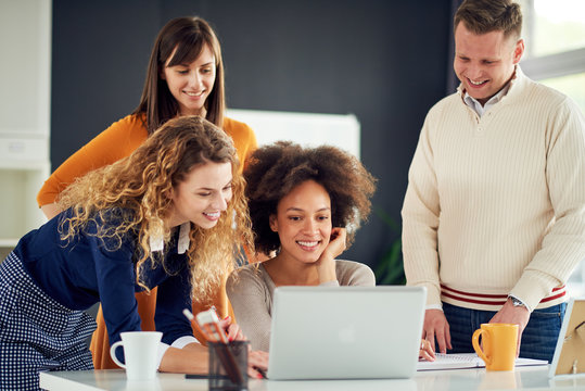 Young People Working In Modern Office, Discussing In Front Of Laptop