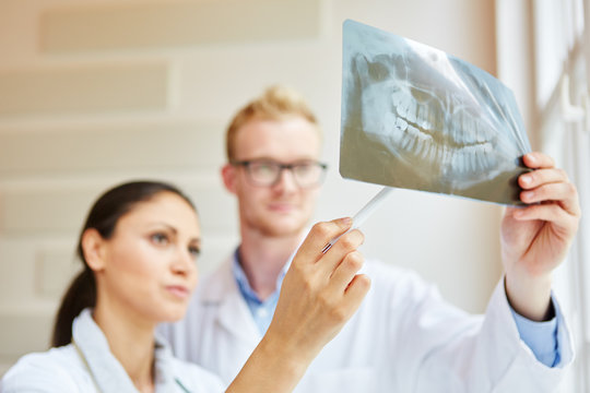 Zahnarzt und Zahnärztin mit Röntgenbild