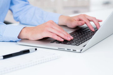 businessfrau schreibt auf laptoptastatur