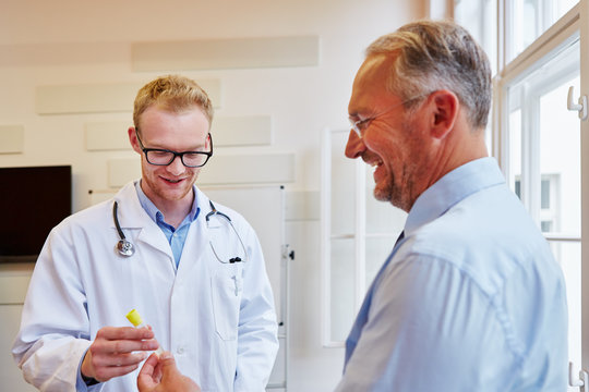 Mann gibt Urinprobe beim Arzt ab