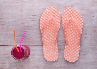 Flip flops and smoothie on wooden background