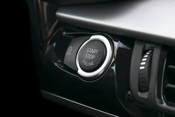 Car dashboard with focus on engine start stop button, car interior details