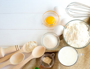 Fototapeta na wymiar Ingredients for the preparation of dough for biscuits. Flour and eggs on a white wooden background.