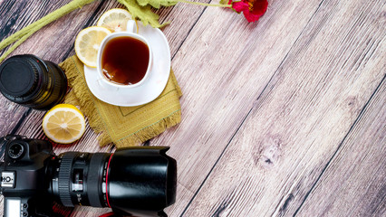 Professional camera with lens and blend on a wooden background with a cup of lemon