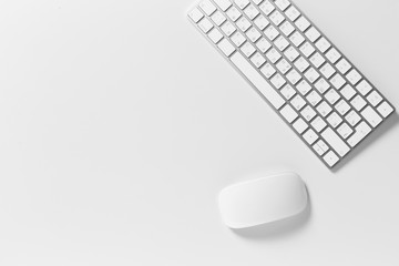 Computer keyboard and mouse on top of white desktop