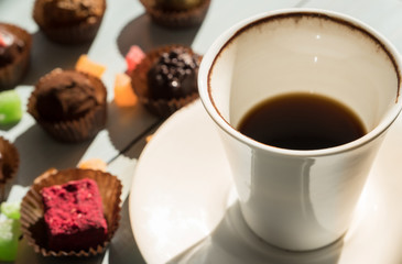 A cup of coffee and chocolate sweets