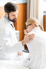 doctor soothing upset colleague