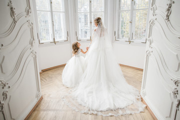 Fototapeta na wymiar The beautiful bride and daughter standing in the room