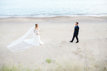 The charming bride and groom standing near sea
