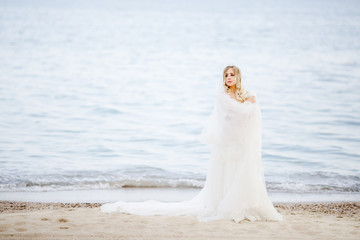 Fototapeta na wymiar The beautiful bride stands near sea