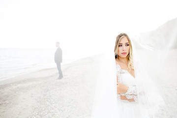 Fototapeta na wymiar The charming bride stands near sea