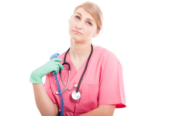 Medical nurse lady holding telephone receiver looking bored