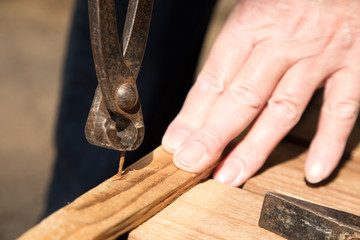 Remove a nail with a pair of pliers