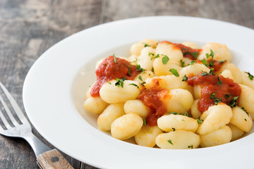 Gnocchi with tomato sauce on wooden background
