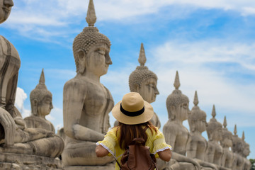 Fototapeta na wymiar Woman tourist photographer is visiting Buddha Park in Thailand.