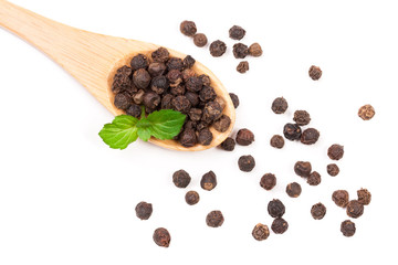 Black peppercorn in a wooden spoon isolated on white background. Top view