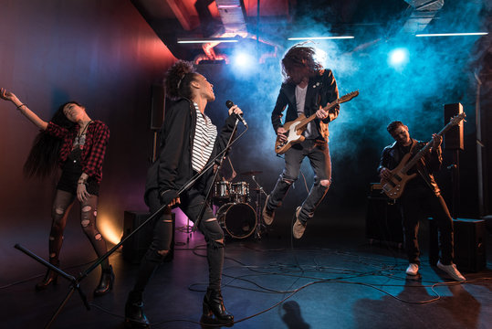 Young multiethnic rock and roll band performing hard rock music on stage  Stock-Foto | Adobe Stock