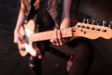Cropped shot of rock and roll girl playing bass guitar on stage