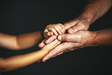 concept of generations. Hand of a child and an elderly person.
