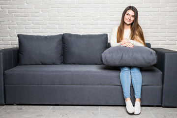 Obraz premium Happy young woman lying on couch and relaxing at home
