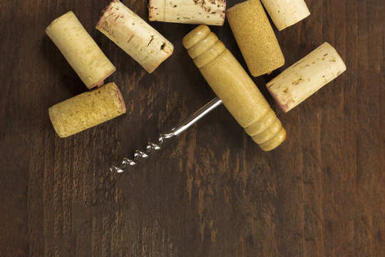 Photo of wine corkscrew and cork on dark background