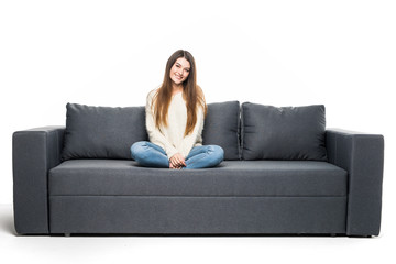 Obraz premium Happy young woman lying on couch and relaxing at home