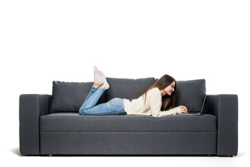 Happy pretty woman using laptop sitting on sofa