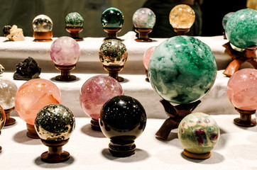 Many crystal therapy spheres on a market stall during a wellness exhibition