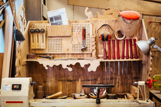 Background image of woodworking workshop: carpenters work table with different tools and wood cutting stand
