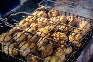 Champignon white mushrooms grilled on grill or barbecue in smoke coals
