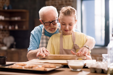 grandfather and granddaughter making dough
