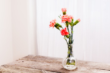 orange blommor i glas vas på trä bordet med utrymme för egen text