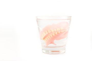 Complete denture is cleaned in a glass of water. proper hygiene.