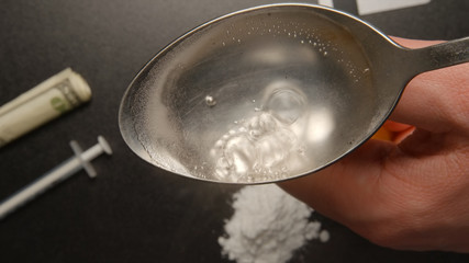 TOP VIEW: Drugs - Heating a heroin in the spoon