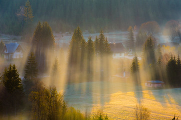 Sunset in the mountains with rays of light and mist
