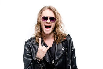 portrait of handsome rocker in black leather jacket and sunglasses showing rock sign isolated on white, rock star concept - obrazy, fototapety, plakaty