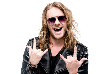 portrait of handsome rocker in black leather jacket and sunglasses showing rock signs isolated on...