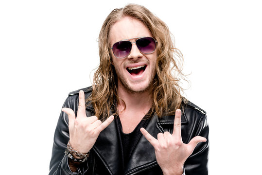 portrait of handsome rocker in black leather jacket and sunglasses showing rock signs isolated on white, rock star concept