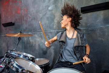 portrait of emotional woman playing drums in studio, drummer rock concept - Powered by Adobe