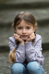 Child sitting on stairs outdoors © Dmytro Surkov