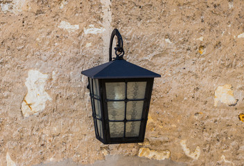 klasyczna czarna lampa na tle kamiennej ściany - obrazy, fototapety, plakaty