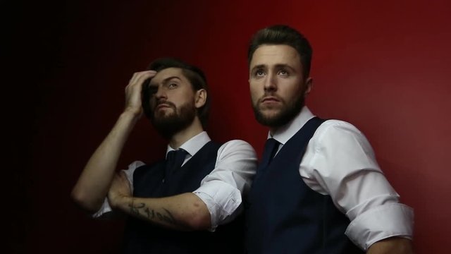 Caucasian young bearded handsome men posing during studio fashion shooting. European hipsters with trendy beards during photo shoot. Guys with fashionable undercuts hairstyle